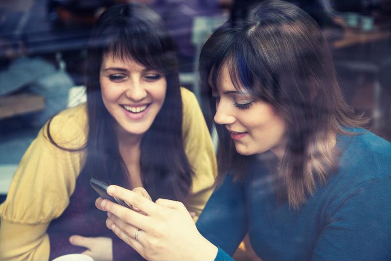 Two women looking at a smartphone.