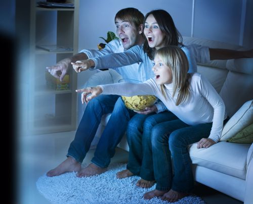 A family of three having fun watching their smart TV. 
