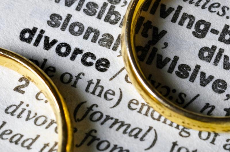 Wedding rings flanking the word "Divorce" in a dictionary. 