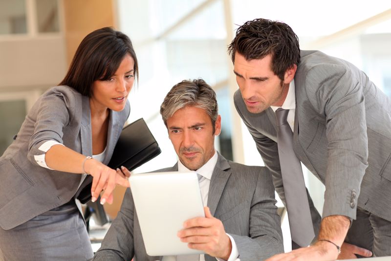 Three co-workers sitting together and working on a project.