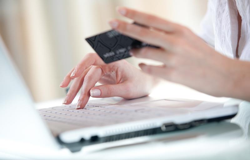 Woman using a credit card to pay a bill online.