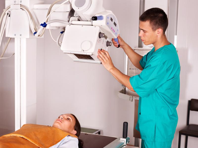 Healthcare professional taking x-ray of patient.