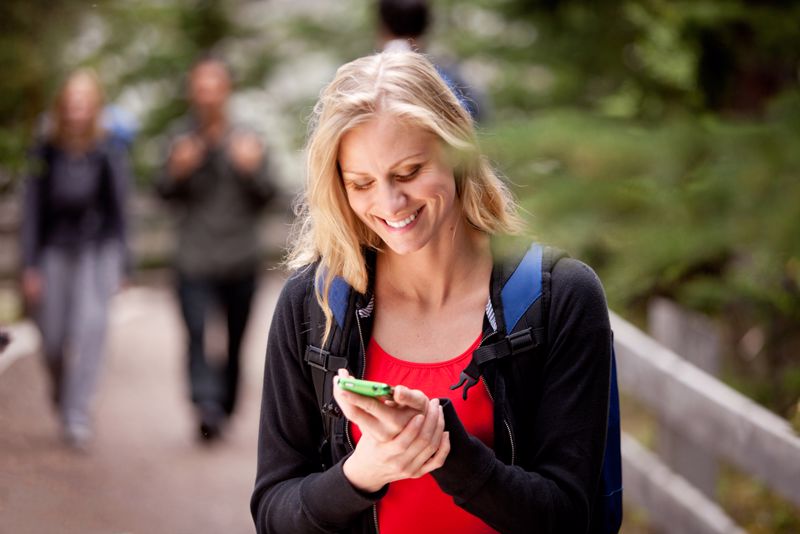 Woman reading a text message while outdoors