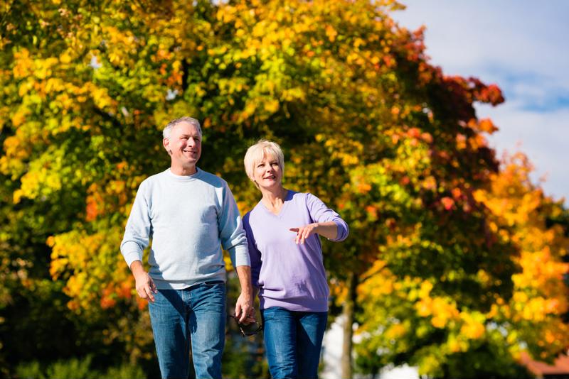 seniors walking on path at apple orchard in fall.