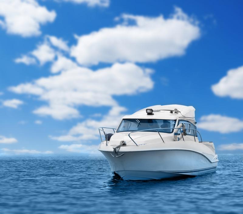 A white boat sits on the open water on a sunny day.