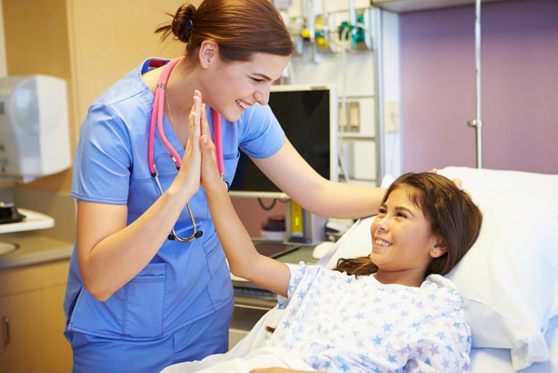 Nurse giving high five to pediatric patient.