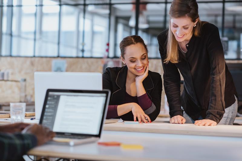 Two women collaborate in an office.