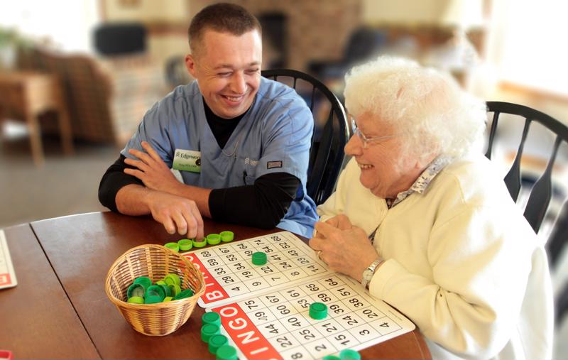 Edgewood senior living staff playing bingo with senior.