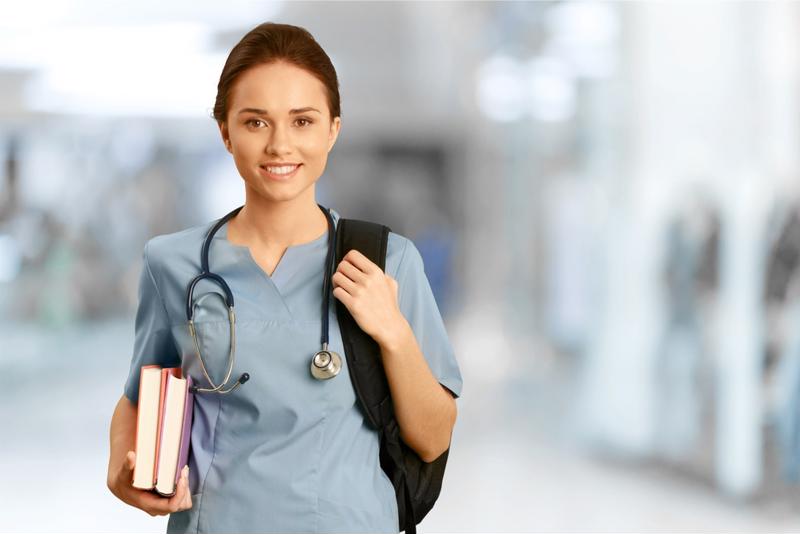 Medical student holding books and backpack.