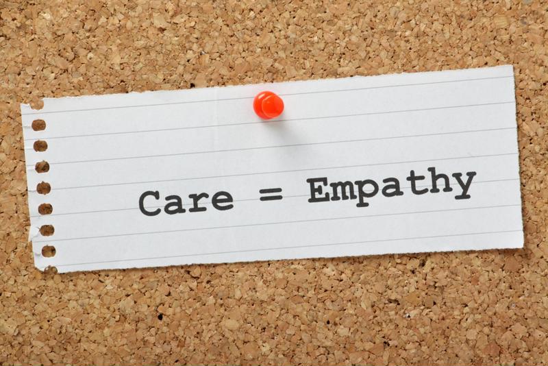 Care = Empathy written on a piece of paper, pinned to a board.
