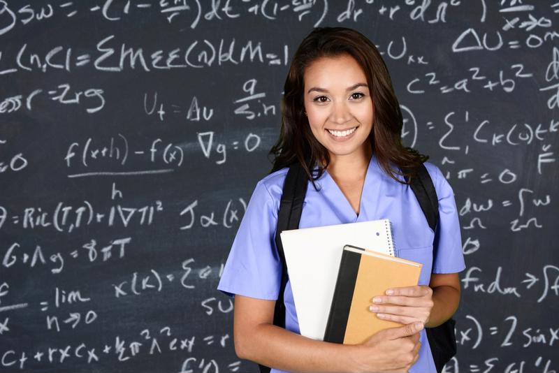 Nursing student standing in front of chalkboard. 
