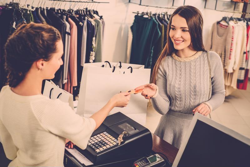 Retail worker and customer interacting beside the cash register. 