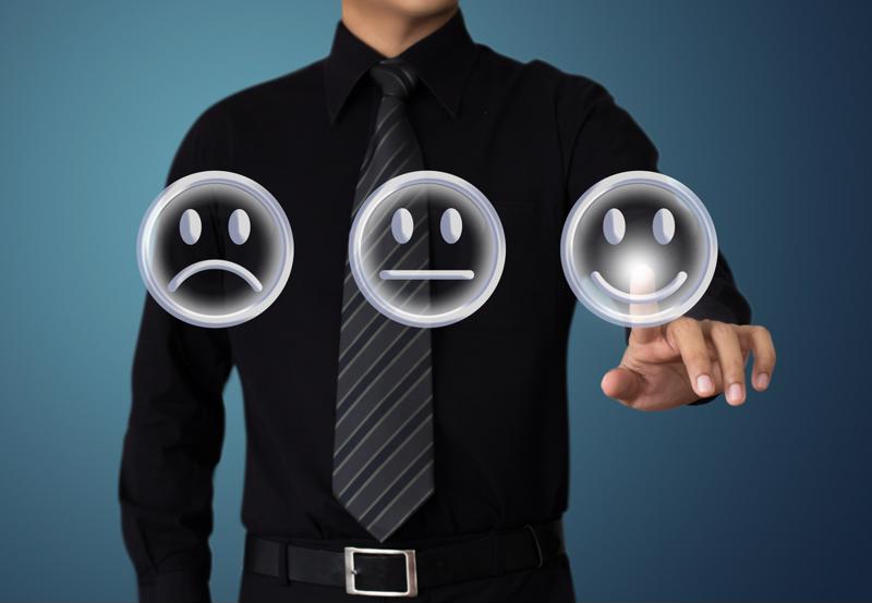 Person with three faces in front of him - one sad, one indifferent, one happy - reaching out to touch/select the happy face. 