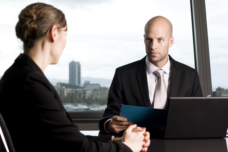 male financial adviser speaking with female client in office with view of city skyline