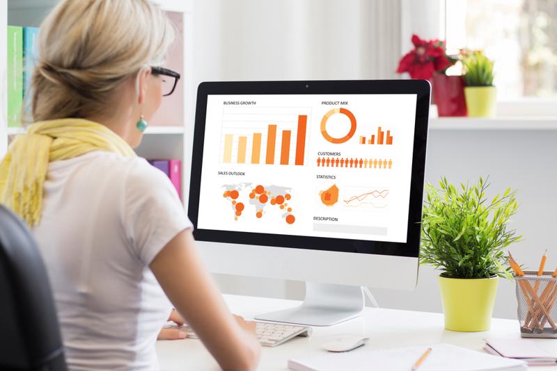 Woman looking at charts on a computer screen at home.