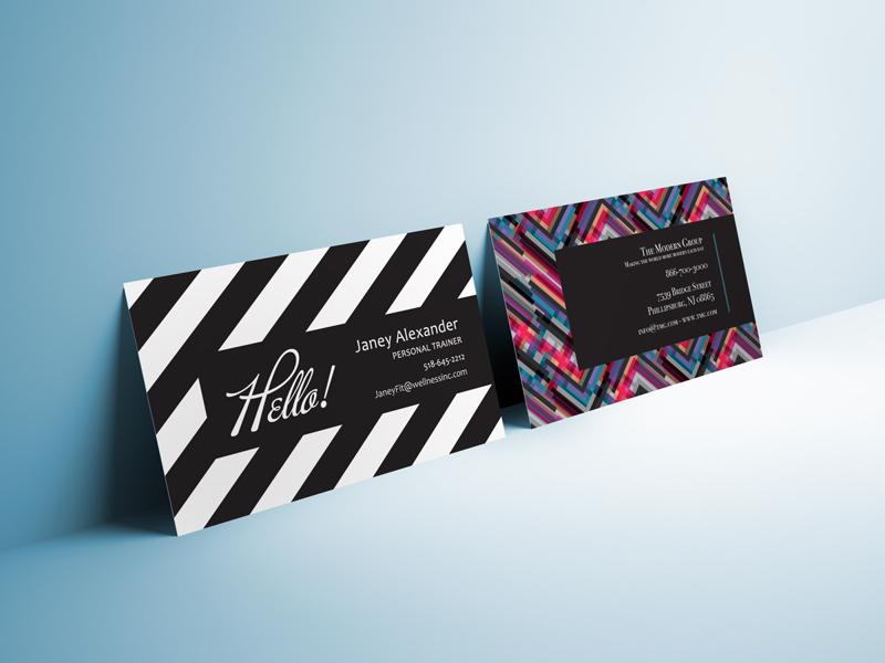 Two business cards propped up against a wall. Colorful and graphic.