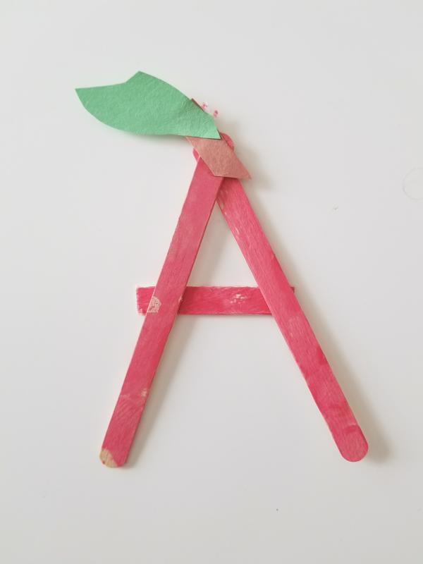 Guide your toddler in arranging the sticks to create the letter A.