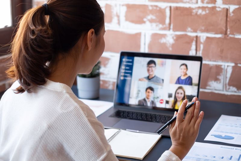 A woman is on a work call with four co-workers on her screen
