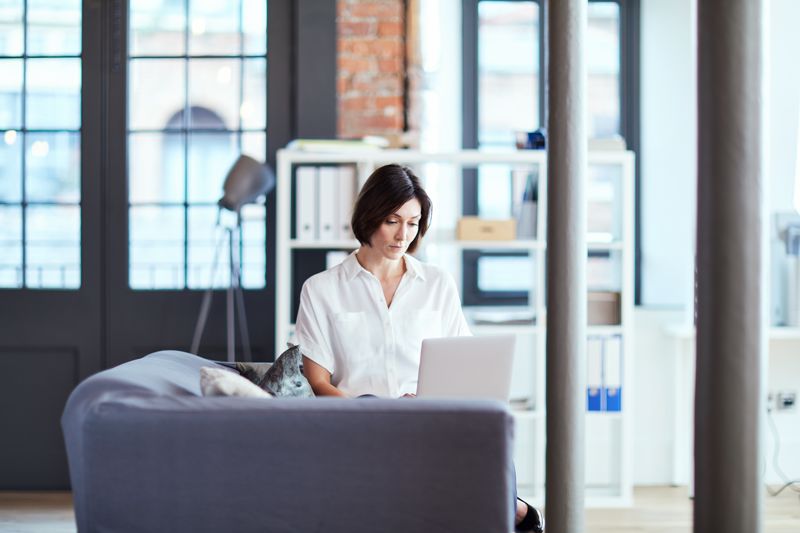 An office worker on her laptop at a lounge.