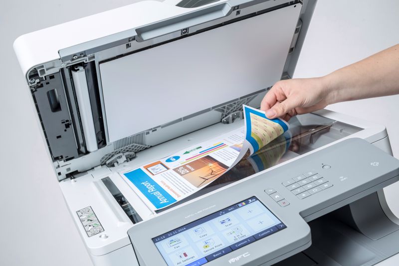 A person scanning a document on a Brother multi-function printer using OCR.