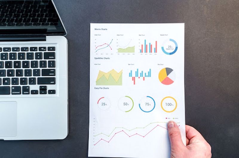 Print analytics on a printed document next to a laptop.