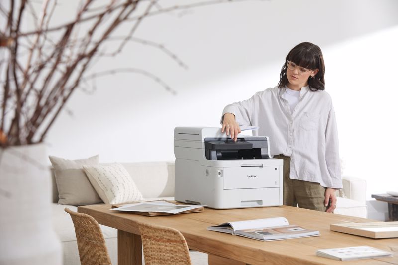 A lady printing sustainably from her printer at home in the living room.