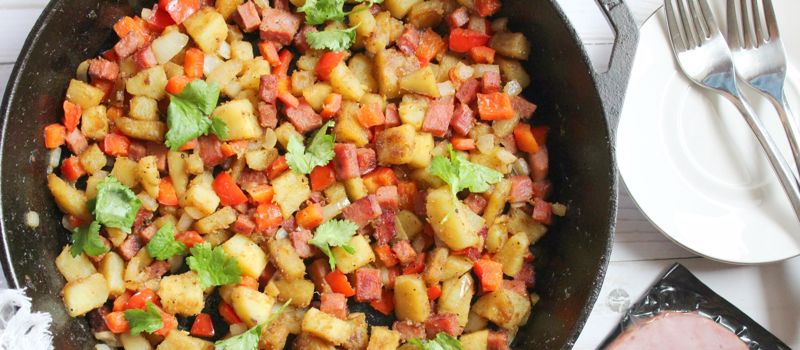 A skillet with sweet potatoes, ham and hash browns