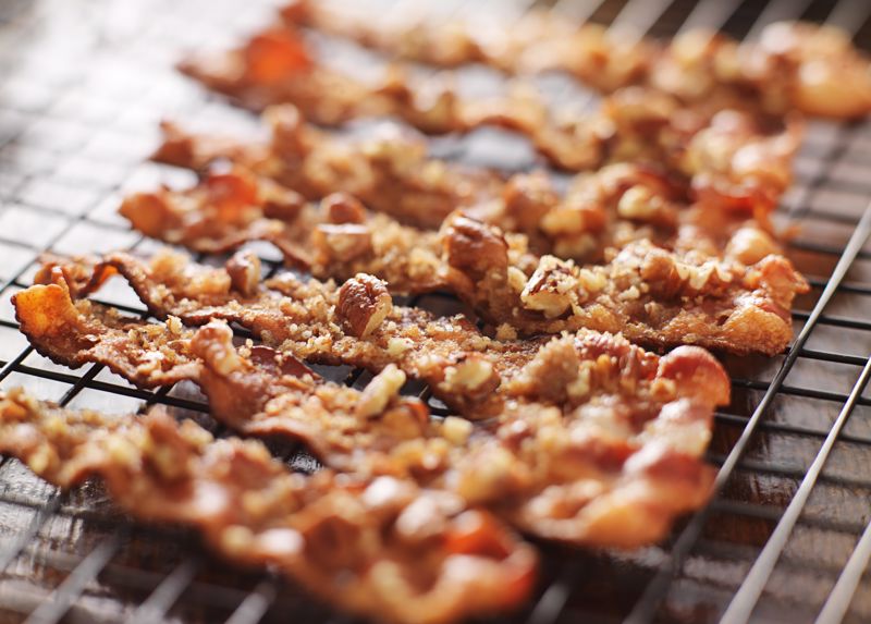 Candied bacon lays across a cooling rack 