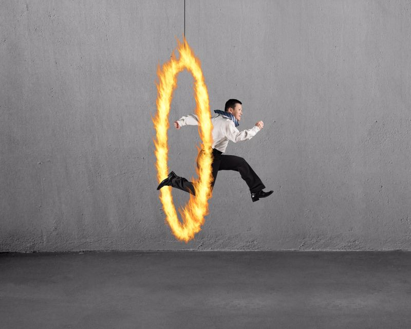 A man is jumping through a hoop on fire.