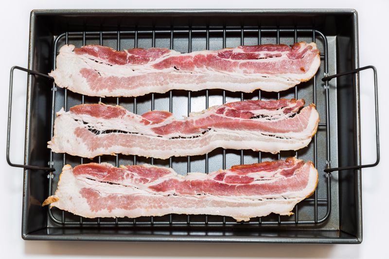 Strips of bacon lay on a wire rack